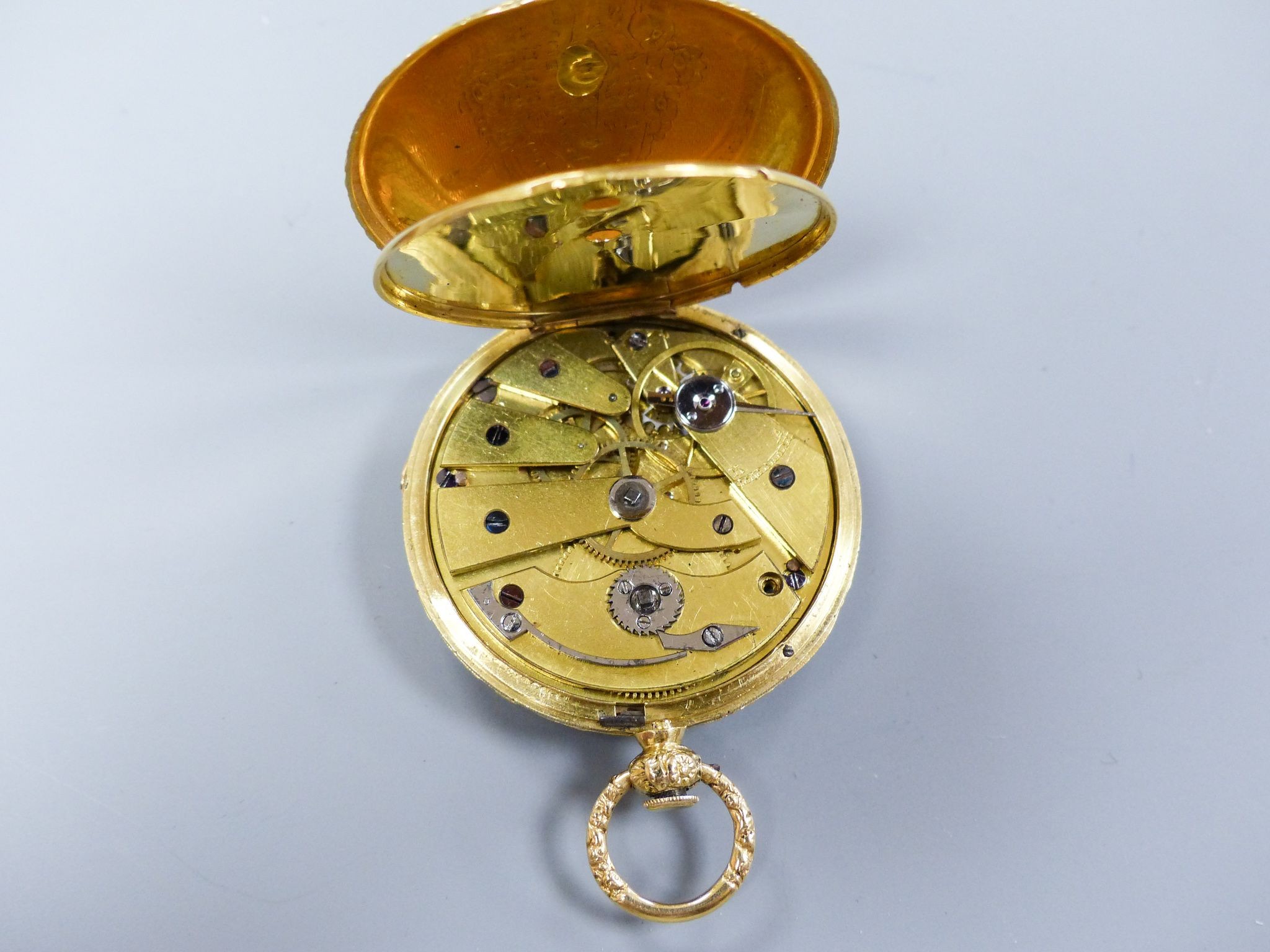 A cased 19th century continental engraved yellow metal open faced fob watch, case diameter 36mm, gross weight 26.6 grams, with watch key.